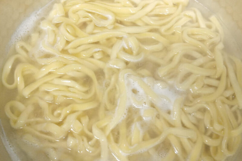 茹でているスパイスカレー旨辛汁なし担々麺の麺